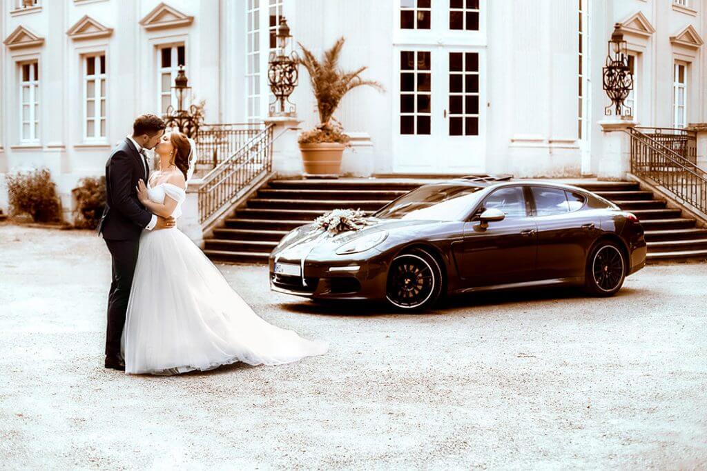 7 Gründe für einen professionellen Hochzeitsfotografen 2 Hochzeitspaar küsst sich vor dem Hochzeitsauto
