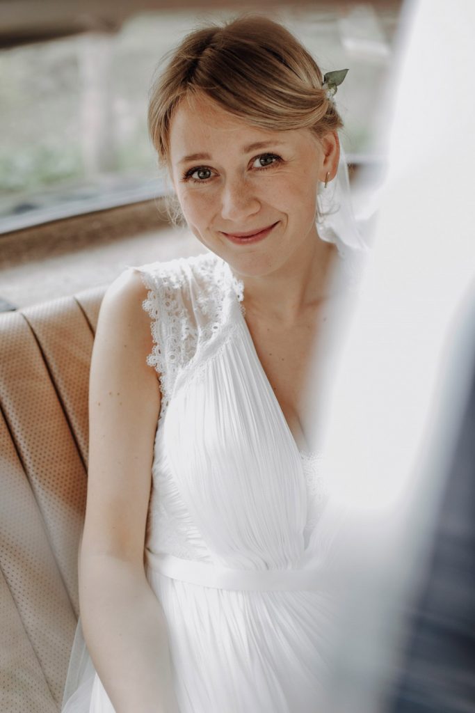 Braut sitzt im Hochzeitsauto
