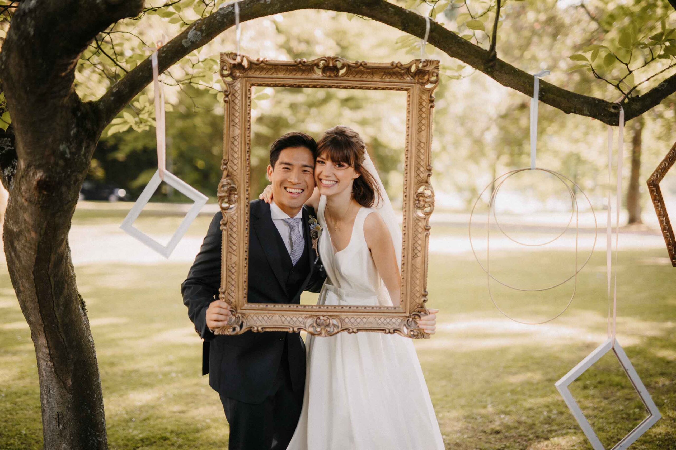 Brautpaar hält einen Bilderrahmen vor sich während eines Fotoshootings