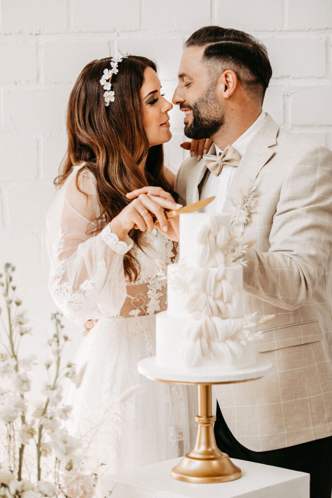 Was ist eine Hochzeitsmesse und lohnt sich ein Besuch? 19 Hochzeitspaar schneidet gemeinsam die Hochzeitstorte an