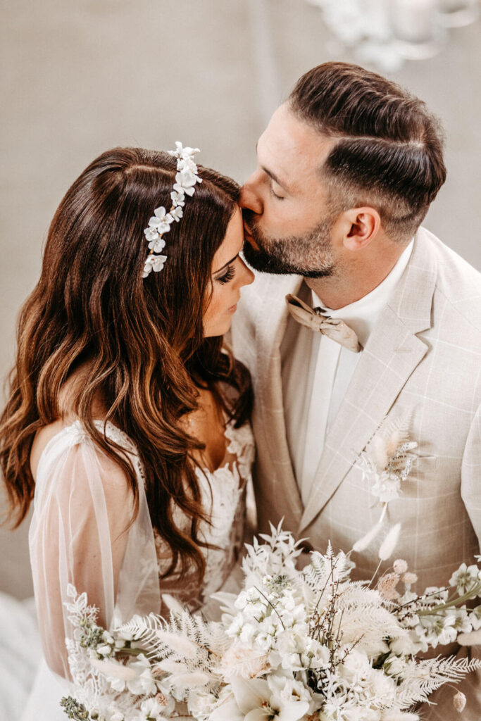 Bräutigam küsst Braut auf die Stirn