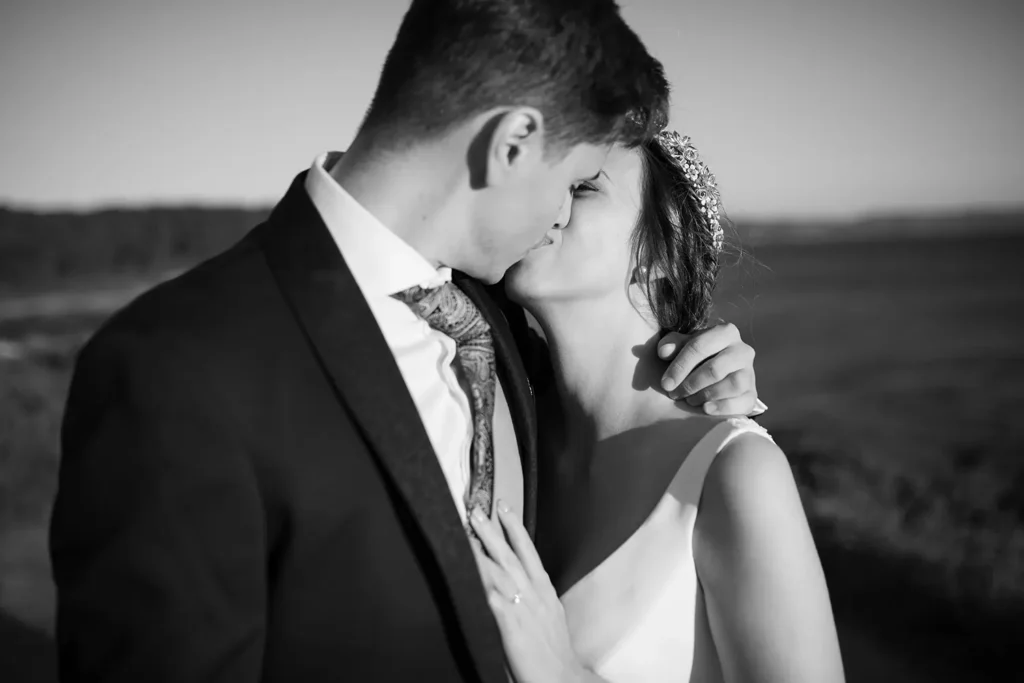 Schwarz-Weiss Hochzeitsfoto eines küssenden Brautpaares